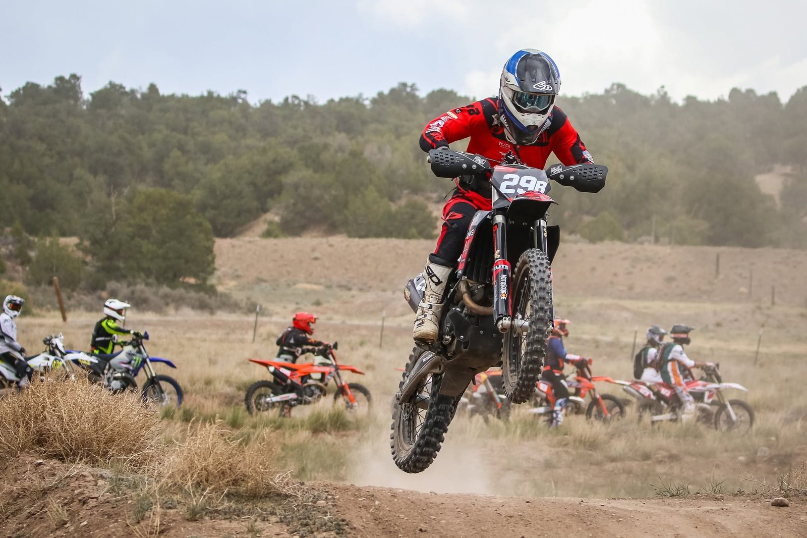A racer in a red jersey clearing a jump during a regional race at Dry Lake, with other riders behind