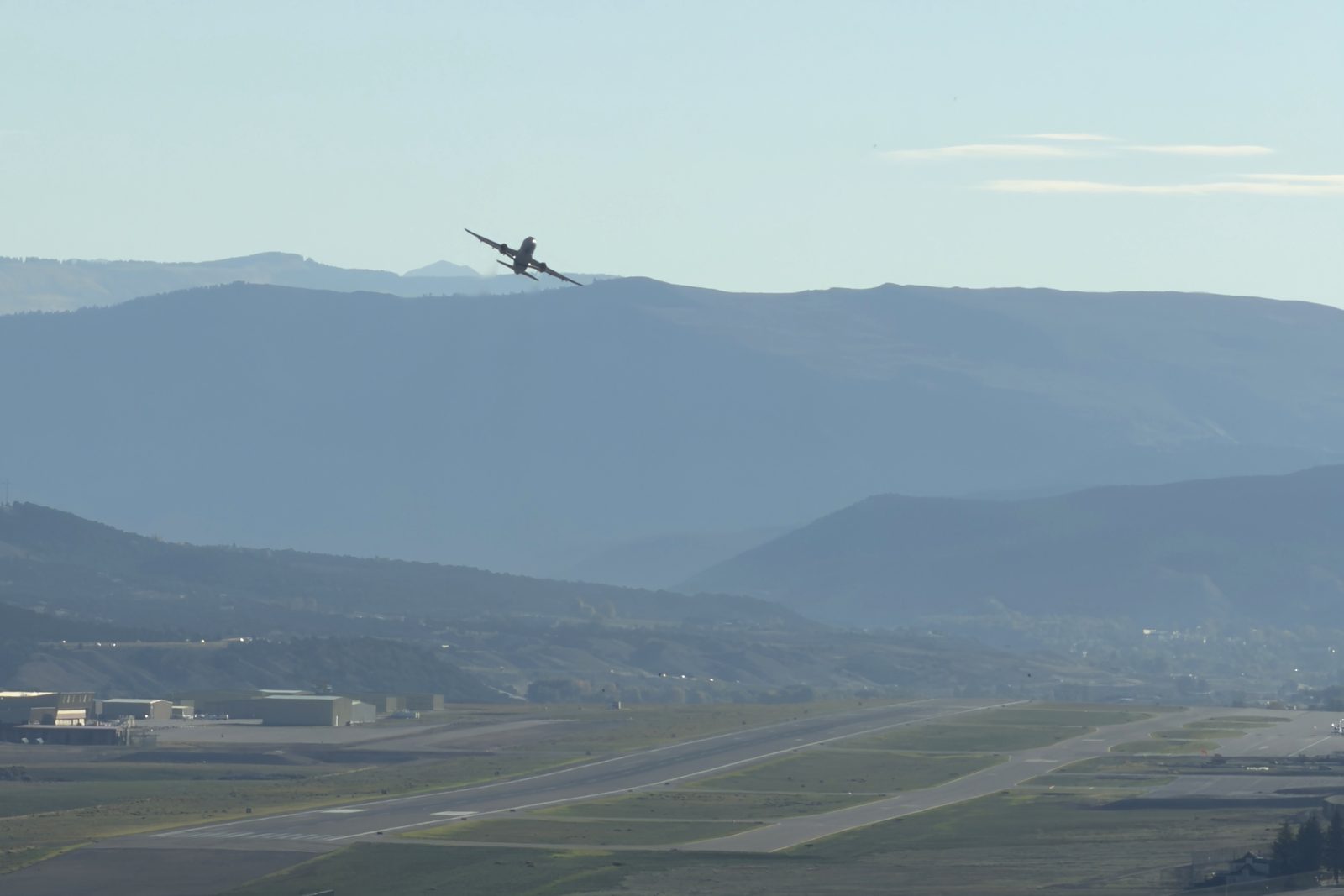 A jet banks over the ridgeline after departing the EGE runway in Gypsum