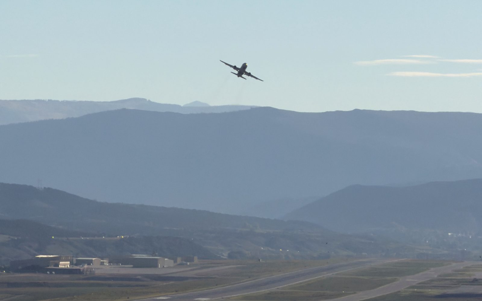 A jet climbs out over the mountains after takeoff from the Eagle County Regional Airport runway in Gypsum, Colorado