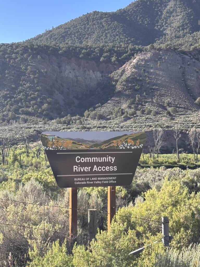 A Bureau of Land Management Community River Access sign on the lower Eagle River below Gypsum, with sage hills behind