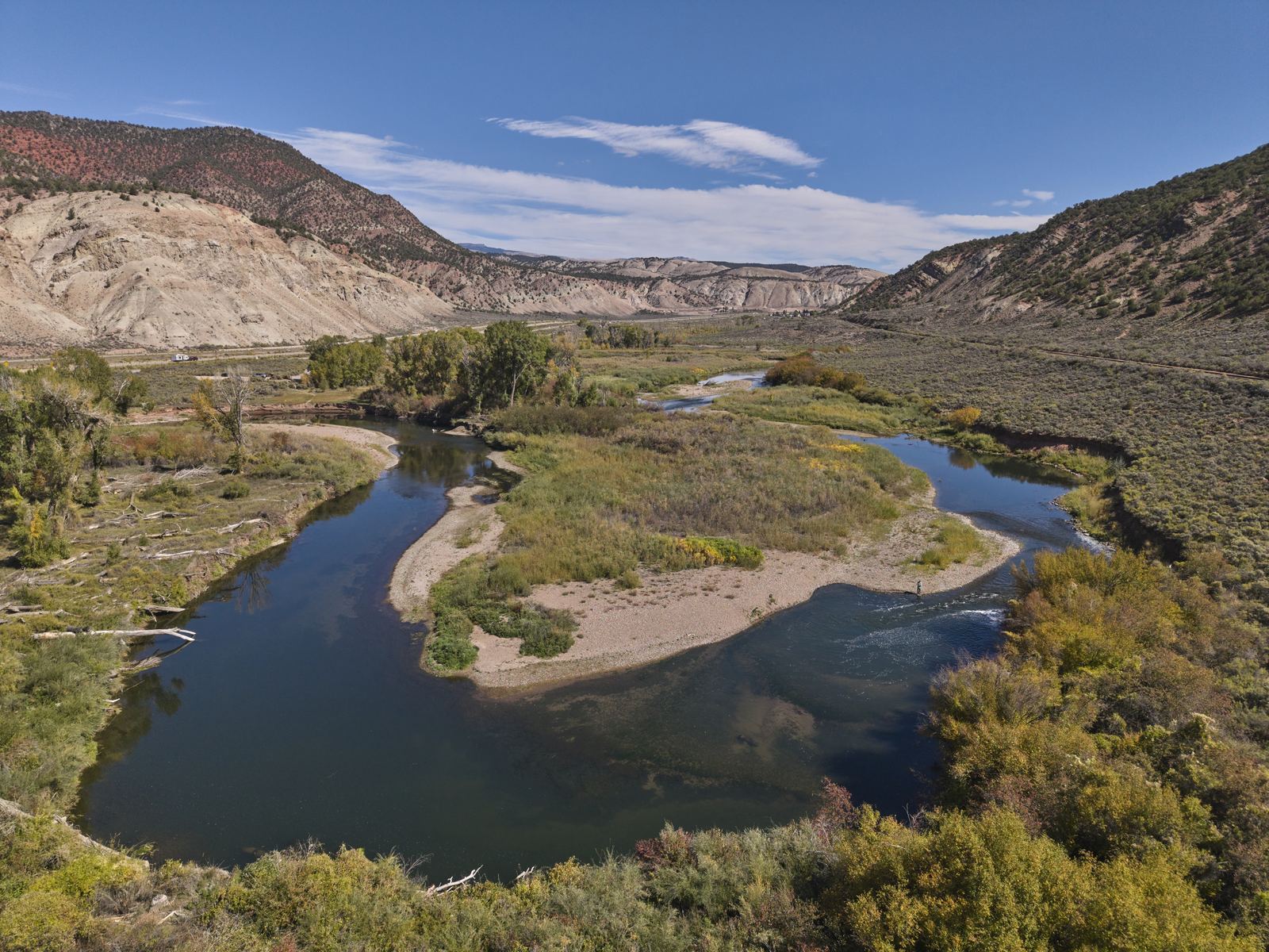 A slow bend of the lower Eagle River downstream from Gypsum, Colorado, past a sandbar and willows under red and white hills