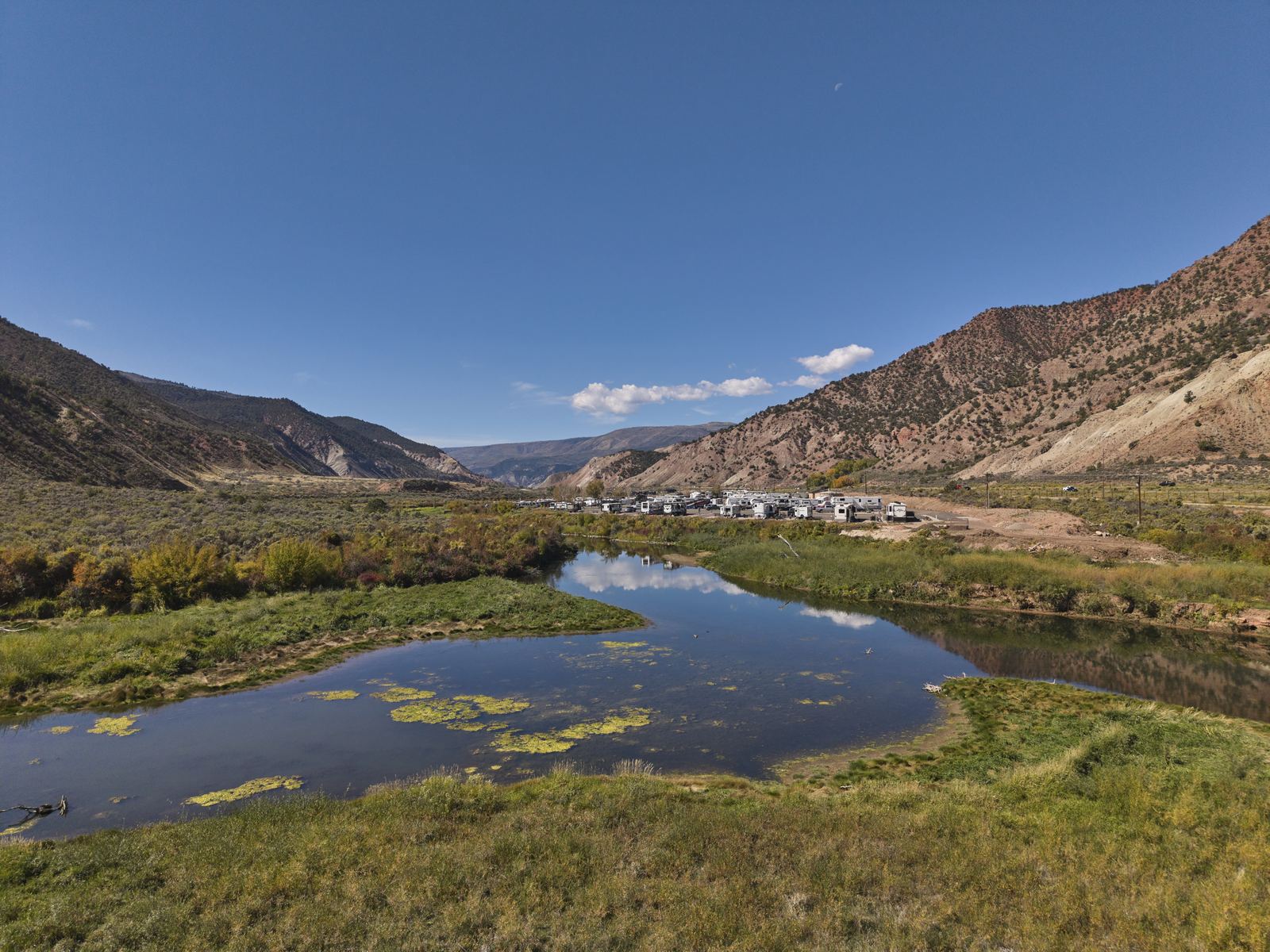 A calm bend of the lower Eagle River west of Gypsum, with an RV campground on the bank and red and white hills around it