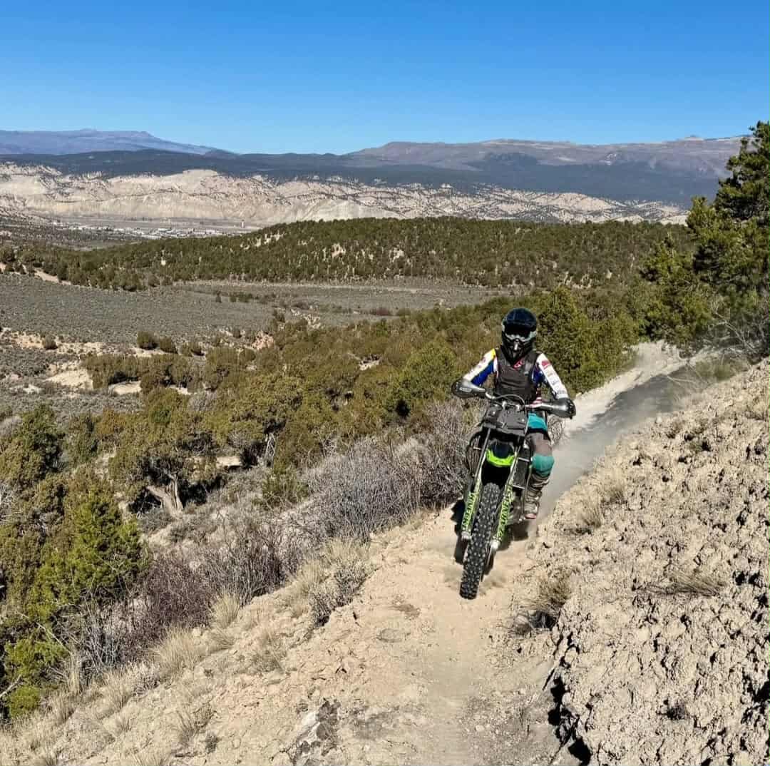 A dirt bike rider on the new Reunion Trail singletrack along a juniper hillside